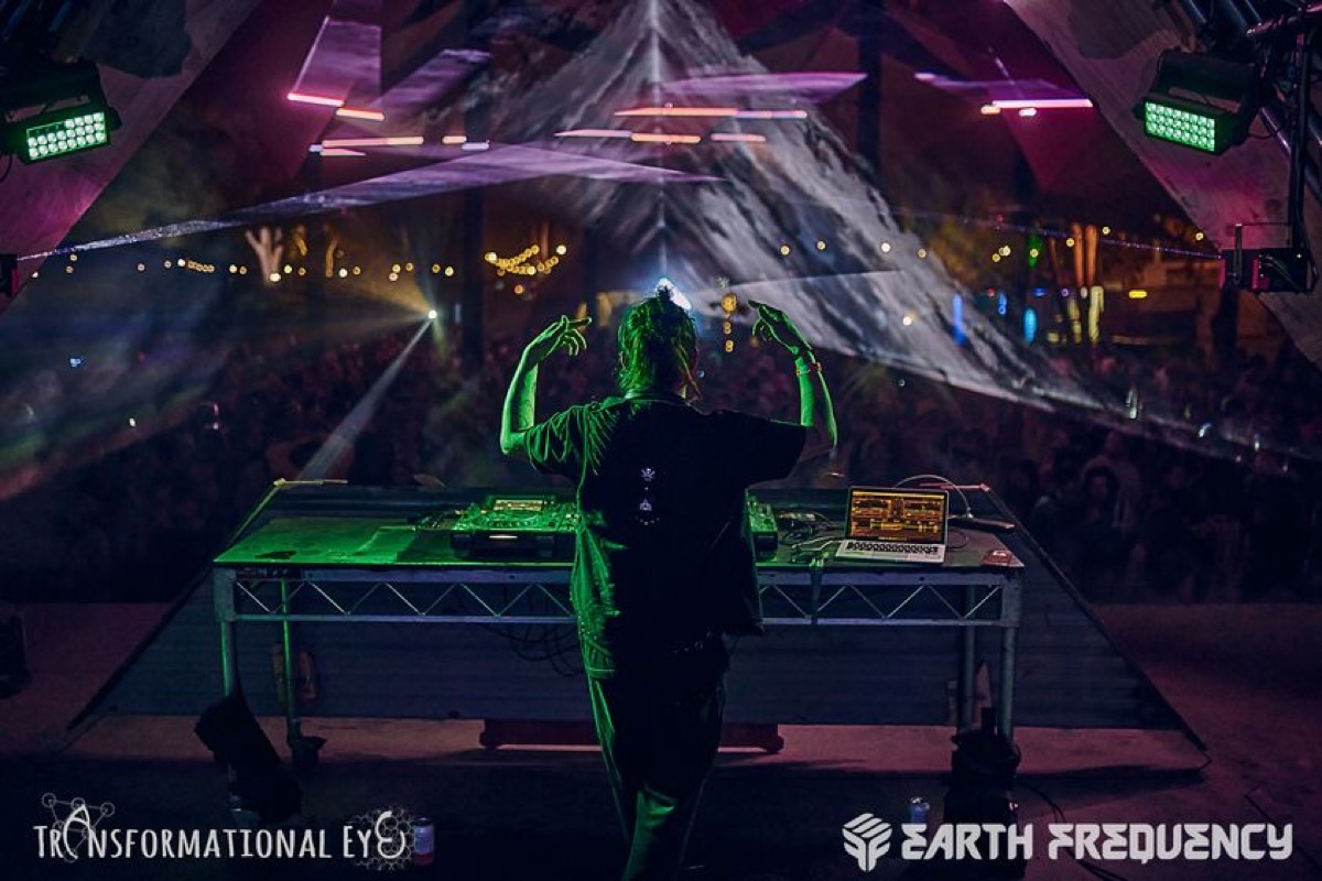 FishEYE with arms up in front of a crowd, 2023, photo by Transformational Eye